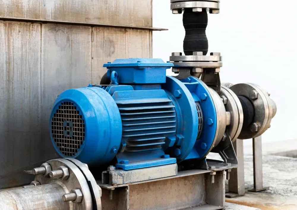 Blue industrial water pump connected to pipes.