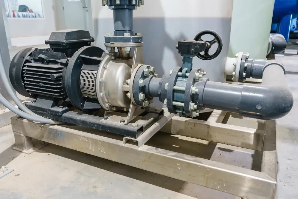 Industrial water pump system with pipes and a motor on a metal platform.